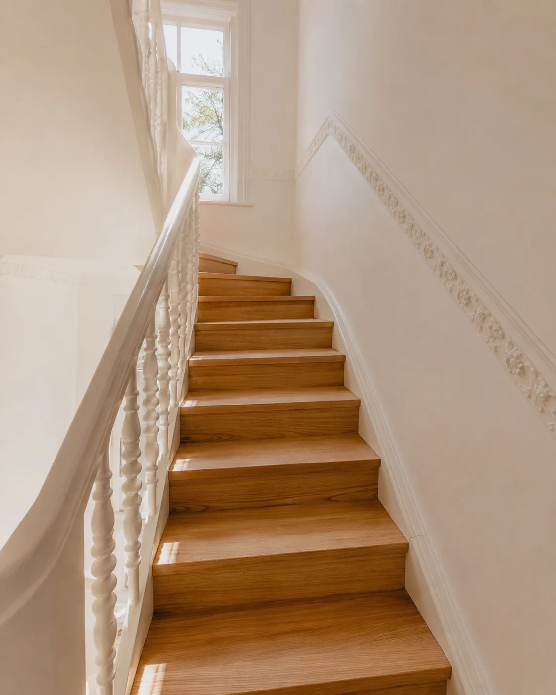 Holztreppe mit weißer Stuckverzierung